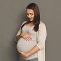 Woman looking down and caressing her pregnant belly